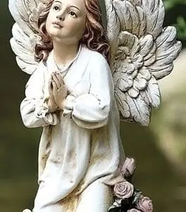 statue angel kneeling praying in a garden