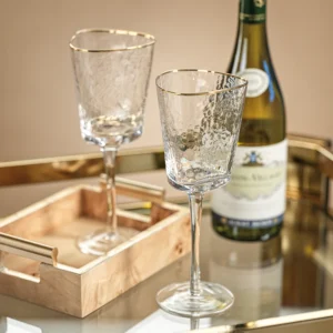Photo of Aperitivo Clear Triangular Wine Glasses With Gold Rim by Zodax on a Tray
